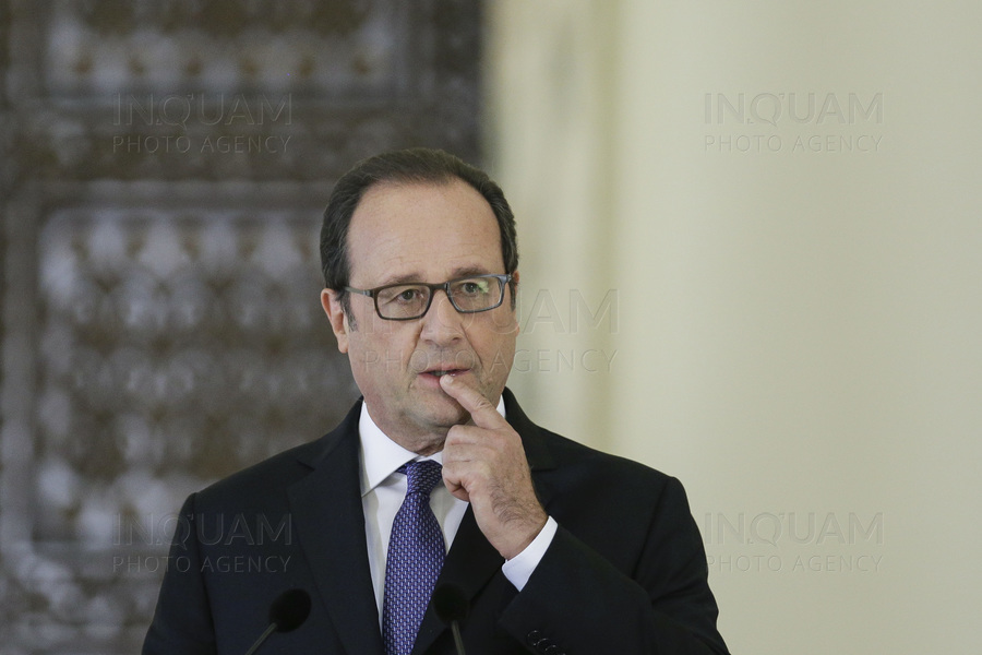 French President Francois Hollande reacts while delivering a speech alongside Romanian President Klaus Iohannis