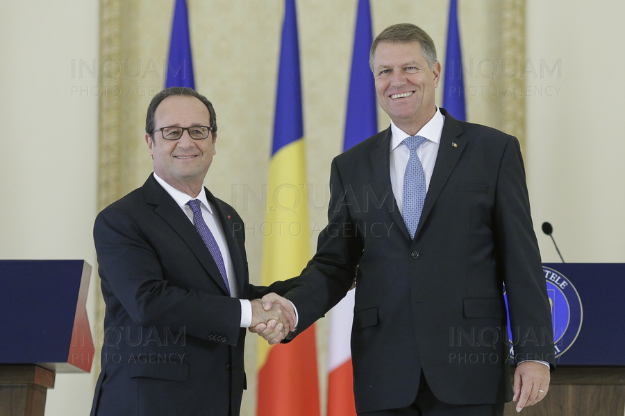 French President Francois Hollande shakes hands with Romanian President Klaus Iohannis