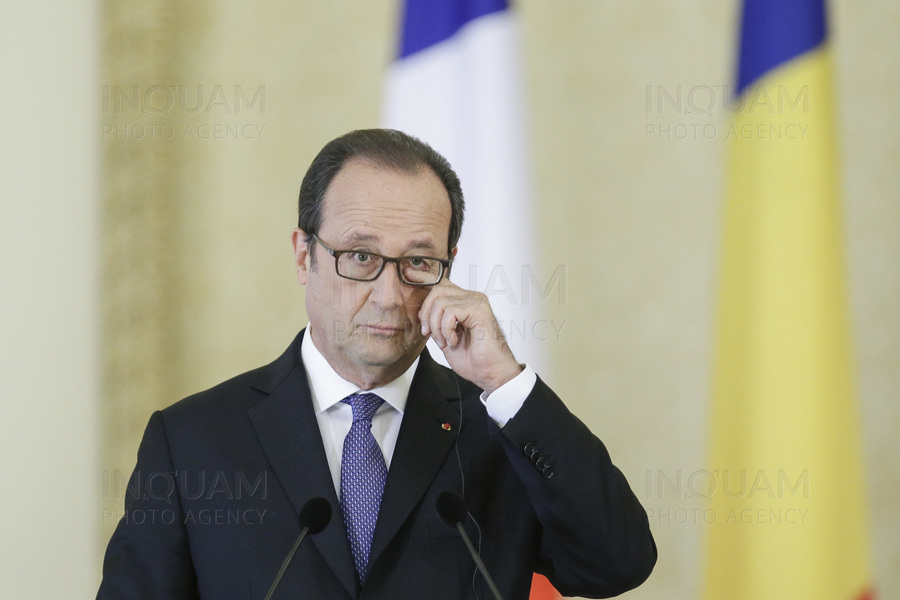 French President Francois Hollande touches his face during a joint press conference with Romanian President Klaus Iohannis